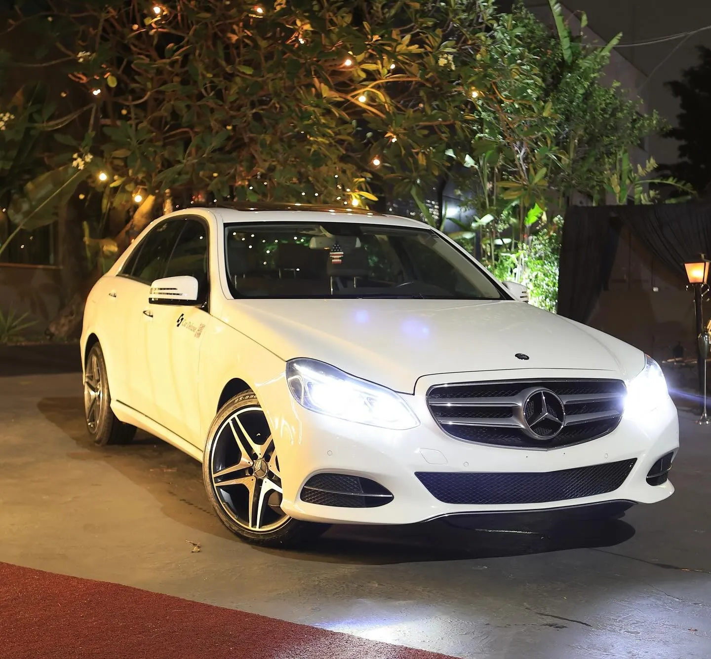 E250 branco à noite na entrada de uma festa