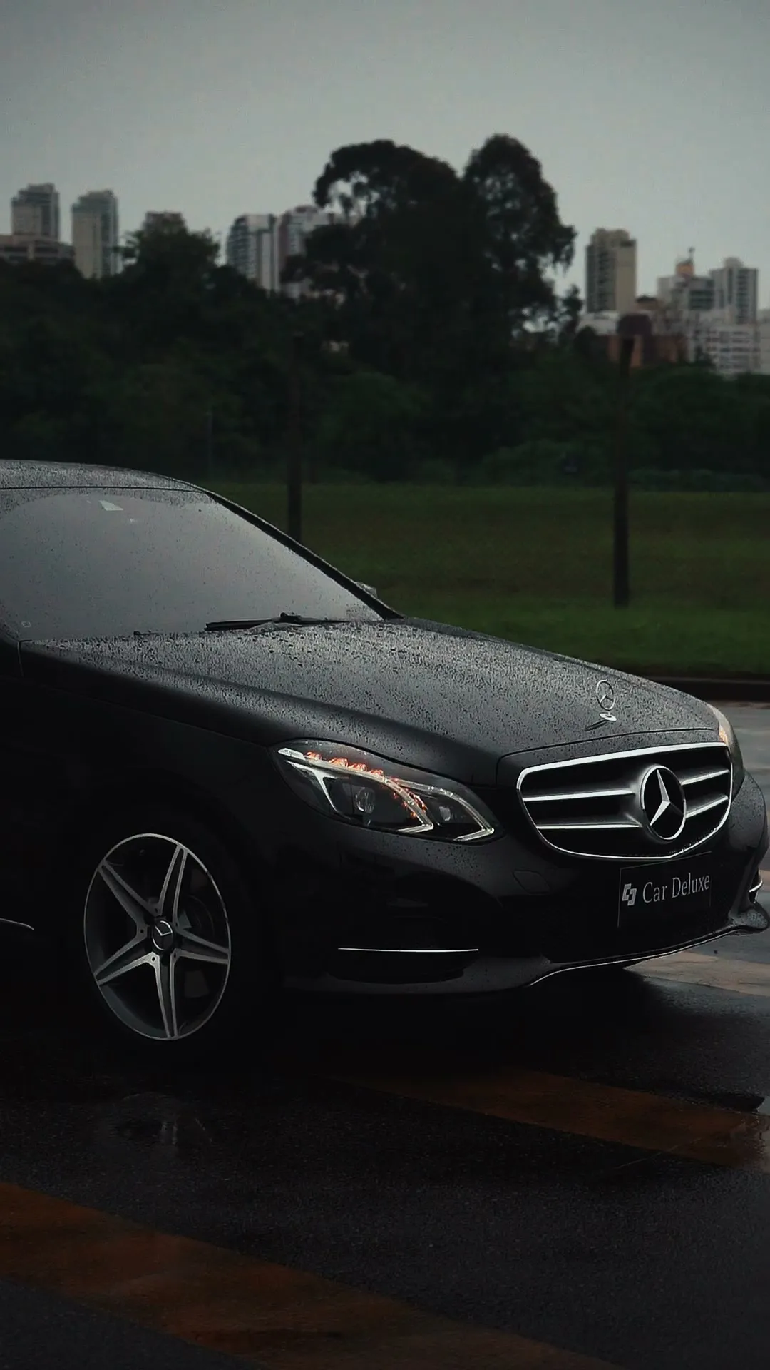 Classe E preto parado, com a cidade ao fundo